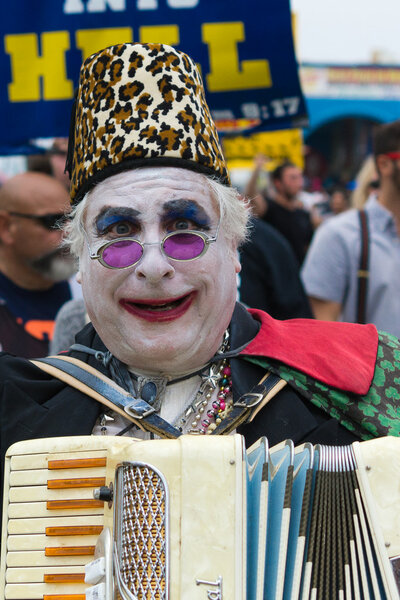 Man with painted face and playing accordion in the 37th Annual Festival of the Chariots