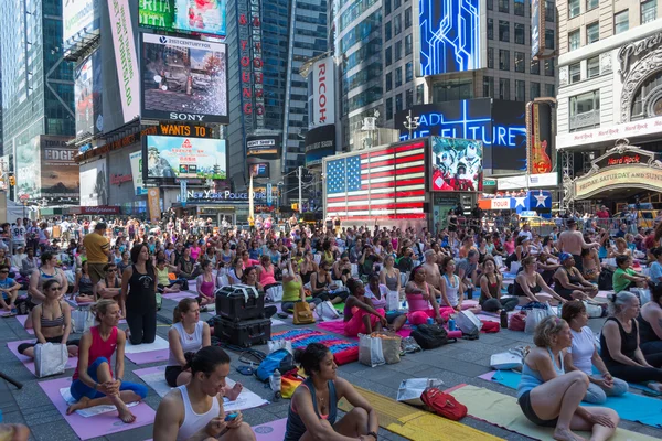 Duizenden van new yorkers beoefenen van yoga in times square. — Stockfoto