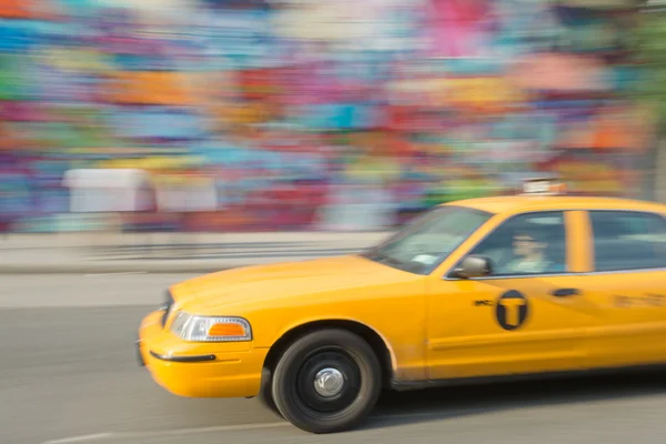 Быстрое такси на улице с цветной стеной — стоковое фото