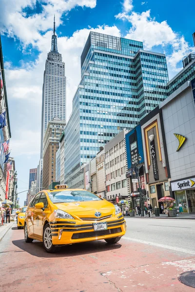 Empire State building and yellow taxi cab on the street — Stock Photo, Image