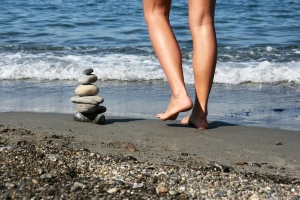 Stos kamieni i kobiece nogi — Zdjęcie stockowe