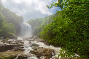 Mustafa Kemal Paşa'da Suuctu şelaleleri, Bursa, Türkiye. Ağaçlar arasında güzel şelale, yeşil yapraklar, kayalar ve nehir arka plan ile gizli ormanda taşlar.