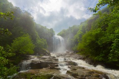 Mustafa Kemal Paşa'da Suuctu şelaleleri, Bursa, Türkiye. Ağaçlar arasında güzel şelale, yeşil yapraklar, kayalar ve nehir arka plan ile gizli ormanda taşlar.