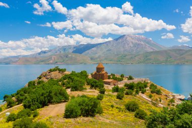 Akdamar Adası 'ndaki Ermeni Kutsal Haç Kilisesi' nin (Akdamar Adasi) bahar manzarası, Van / Türkiye Gölü. Akdamar Adası 'nın ortasında, çiçeklerle çevrili bir ağaçla.
