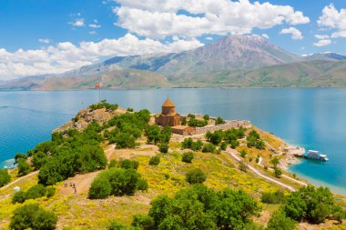 Akdamar Adası 'ndaki Ermeni Kutsal Haç Kilisesi' nin (Akdamar Adasi) bahar manzarası, Van / Türkiye Gölü. Akdamar Adası 'nın ortasında, çiçeklerle çevrili bir ağaçla.