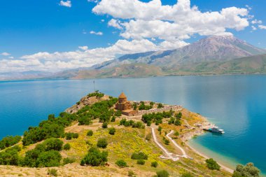 Akdamar Adası 'ndaki Ermeni Kutsal Haç Kilisesi' nin (Akdamar Adasi) bahar manzarası, Van / Türkiye Gölü. Akdamar Adası 'nın ortasında, çiçeklerle çevrili bir ağaçla.