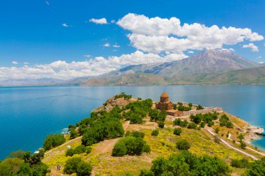 Akdamar Adası 'ndaki Ermeni Kutsal Haç Kilisesi' nin (Akdamar Adasi) bahar manzarası, Van / Türkiye Gölü. Akdamar Adası 'nın ortasında, çiçeklerle çevrili bir ağaçla.