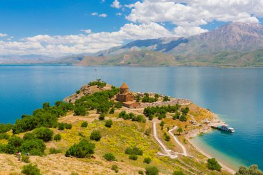 Akdamar Adası 'ndaki Ermeni Kutsal Haç Kilisesi' nin (Akdamar Adasi) bahar manzarası, Van / Türkiye Gölü. Akdamar Adası 'nın ortasında, çiçeklerle çevrili bir ağaçla.