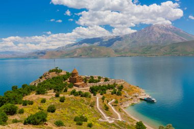 Akdamar Adası 'ndaki Ermeni Kutsal Haç Kilisesi' nin (Akdamar Adasi) bahar manzarası, Van / Türkiye Gölü. Akdamar Adası 'nın ortasında, çiçeklerle çevrili bir ağaçla.