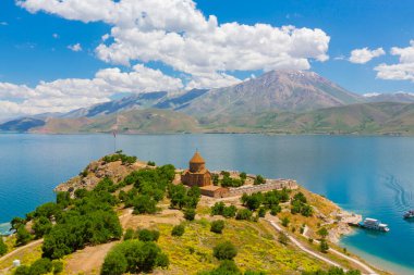 Akdamar Adası 'ndaki Ermeni Kutsal Haç Kilisesi' nin (Akdamar Adasi) bahar manzarası, Van / Türkiye Gölü. Akdamar Adası 'nın ortasında, çiçeklerle çevrili bir ağaçla.