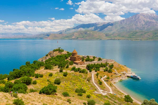 Akdamar Adası 'ndaki Ermeni Kutsal Haç Kilisesi' nin (Akdamar Adasi) bahar manzarası, Van / Türkiye Gölü. Akdamar Adası 'nın ortasında, çiçeklerle çevrili bir ağaçla.