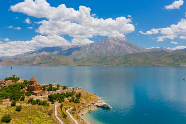 Akdamar Adası 'ndaki Ermeni Kutsal Haç Kilisesi' nin (Akdamar Adasi) bahar manzarası, Van / Türkiye Gölü. Akdamar Adası 'nın ortasında, çiçeklerle çevrili bir ağaçla.