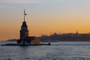 İstanbul, Türkiye 'nin sembolü Leander' s Tower olarak da bilinen ünlü Maiden 's Tower (Kiz Kulesi) ile Boğaz' ın üzerinde kızgın bir günbatımı. Duvar kağıdı veya rehber kitap için sahne yolculuğu arkaplanı