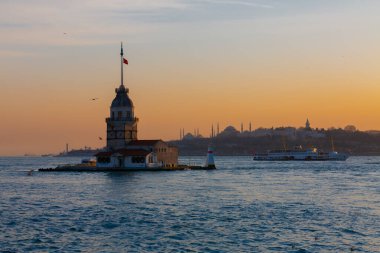 İstanbul, Türkiye 'nin sembolü Leander' s Tower olarak da bilinen ünlü Maiden 's Tower (Kiz Kulesi) ile Boğaz' ın üzerinde kızgın bir günbatımı. Duvar kağıdı veya rehber kitap için sahne yolculuğu arkaplanı