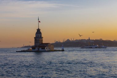 İstanbul, Türkiye 'nin sembolü Leander' s Tower olarak da bilinen ünlü Maiden 's Tower (Kiz Kulesi) ile Boğaz' ın üzerinde kızgın bir günbatımı. Duvar kağıdı veya rehber kitap için sahne yolculuğu arkaplanı