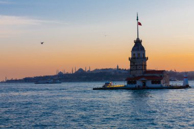 İstanbul, Türkiye 'nin sembolü Leander' s Tower olarak da bilinen ünlü Maiden 's Tower (Kiz Kulesi) ile Boğaz' ın üzerinde kızgın bir günbatımı. Duvar kağıdı veya rehber kitap için sahne yolculuğu arkaplanı