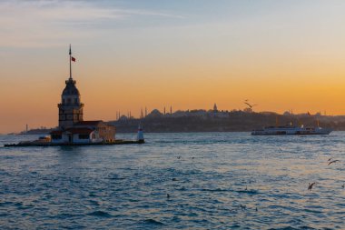 İstanbul, Türkiye 'nin sembolü Leander' s Tower olarak da bilinen ünlü Maiden 's Tower (Kiz Kulesi) ile Boğaz' ın üzerinde kızgın bir günbatımı. Duvar kağıdı veya rehber kitap için sahne yolculuğu arkaplanı