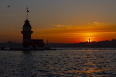 İstanbul, Türkiye 'nin sembolü Leander' s Tower olarak da bilinen ünlü Maiden 's Tower (Kiz Kulesi) ile Boğaz' ın üzerinde kızgın bir günbatımı. Duvar kağıdı veya rehber kitap için sahne yolculuğu arkaplanı