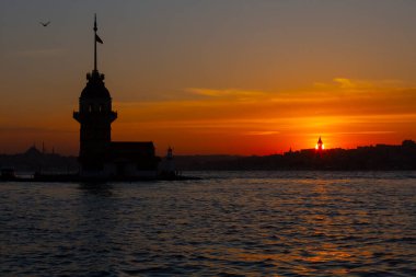 İstanbul, Türkiye 'nin sembolü Leander' s Tower olarak da bilinen ünlü Maiden 's Tower (Kiz Kulesi) ile Boğaz' ın üzerinde kızgın bir günbatımı. Duvar kağıdı veya rehber kitap için sahne yolculuğu arkaplanı