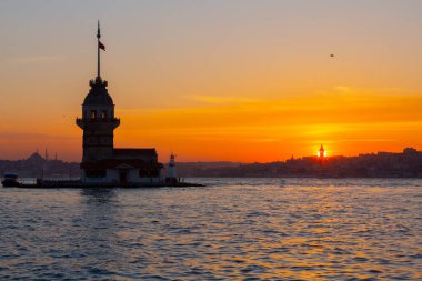 İstanbul, Türkiye 'nin sembolü Leander' s Tower olarak da bilinen ünlü Maiden 's Tower (Kiz Kulesi) ile Boğaz' ın üzerinde kızgın bir günbatımı. Duvar kağıdı veya rehber kitap için sahne yolculuğu arkaplanı