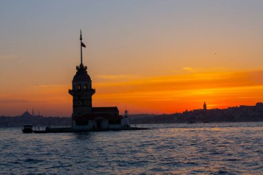 İstanbul, Türkiye 'nin sembolü Leander' s Tower olarak da bilinen ünlü Maiden 's Tower (Kiz Kulesi) ile Boğaz' ın üzerinde kızgın bir günbatımı. Duvar kağıdı veya rehber kitap için sahne yolculuğu arkaplanı