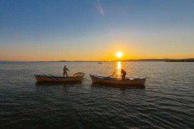 Gün batımında göl balıkçısı