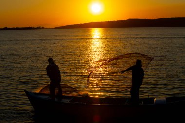 Gün batımında göl balıkçısı