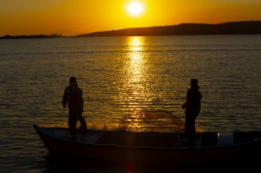 Gün batımında göl balıkçısı