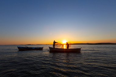 Gün batımında göl balıkçısı