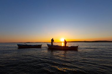 Gün batımında göl balıkçısı