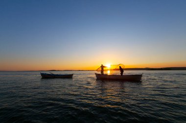 Gün batımında göl balıkçısı