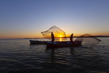 Gün batımında göl balıkçısı