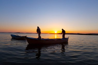 Gün batımında göl balıkçısı