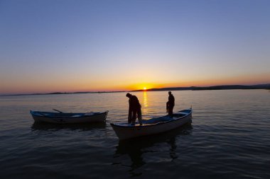 Gün batımında göl balıkçısı