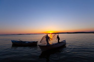 Gün batımında göl balıkçısı
