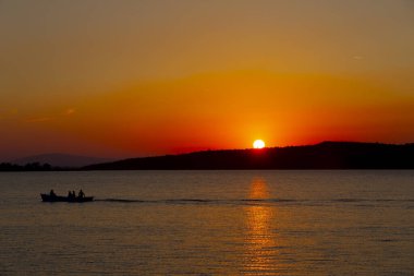 Gün batımında göl balıkçısı