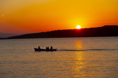 Gün batımında göl balıkçısı