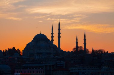 Günbatımı İstanbul, Türkiye 'de Süleyman Camii (Osmanlı İmparatorluğu Camii) ile birlikte. İstanbul 'daki Galata Köprüsü' nden görüntü.