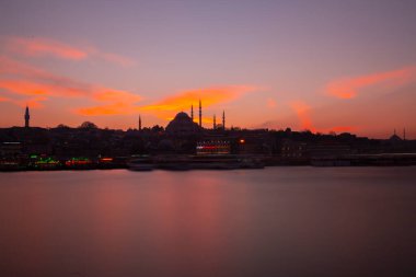 Günbatımı İstanbul, Türkiye 'de Süleyman Camii (Osmanlı İmparatorluğu Camii) ile birlikte. İstanbul 'daki Galata Köprüsü' nden görüntü.