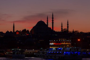 Günbatımı İstanbul, Türkiye 'de Süleyman Camii (Osmanlı İmparatorluğu Camii) ile birlikte. İstanbul 'daki Galata Köprüsü' nden görüntü.