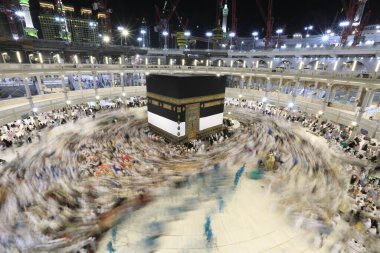 Umra ya da Hac zamanlarında Mekke 'deki Kutsal Kabe' nin etrafında Tawaf yapan bir grup insan Mescid-i Haram 'ın tepesinden bakıyor. Geceleri uzun pozlama