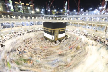Umra ya da Hac zamanlarında Mekke 'deki Kutsal Kabe' nin etrafında Tawaf yapan bir grup insan Mescid-i Haram 'ın tepesinden bakıyor. Geceleri uzun pozlama