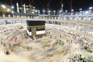 Umra ya da Hac zamanlarında Mekke 'deki Kutsal Kabe' nin etrafında Tawaf yapan bir grup insan Mescid-i Haram 'ın tepesinden bakıyor. Geceleri uzun pozlama