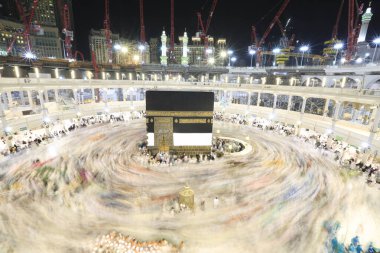Umra ya da Hac zamanlarında Mekke 'deki Kutsal Kabe' nin etrafında Tawaf yapan bir grup insan Mescid-i Haram 'ın tepesinden bakıyor. Geceleri uzun pozlama