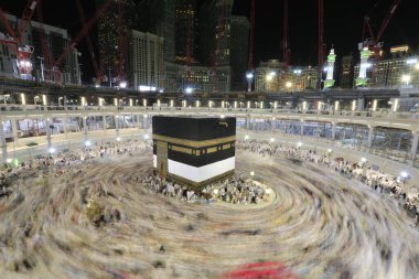 Umra ya da Hac zamanlarında Mekke 'deki Kutsal Kabe' nin etrafında Tawaf yapan bir grup insan Mescid-i Haram 'ın tepesinden bakıyor. Geceleri uzun pozlama