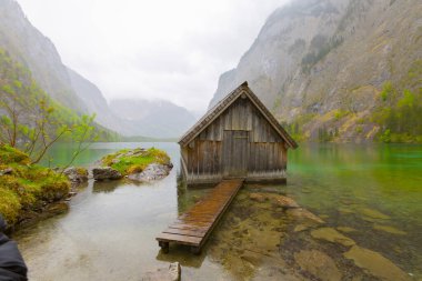 Yaz aylarında mavi gökyüzü ve bulutlar ile güzel bir güneşli bir günde doğal Obersee Gölü'nde geleneksel eski ahşap tekne evi Pastoral görünümü, Millipark Berchtesgadener Land, Bavyera, Almanya