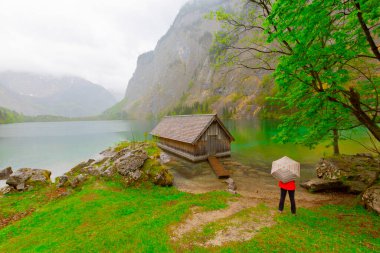 Yaz aylarında mavi gökyüzü ve bulutlar ile güzel bir güneşli bir günde doğal Obersee Gölü'nde geleneksel eski ahşap tekne evi Pastoral görünümü, Millipark Berchtesgadener Land, Bavyera, Almanya