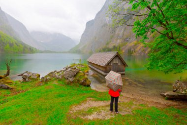 Yaz aylarında mavi gökyüzü ve bulutlar ile güzel bir güneşli bir günde doğal Obersee Gölü'nde geleneksel eski ahşap tekne evi Pastoral görünümü, Millipark Berchtesgadener Land, Bavyera, Almanya