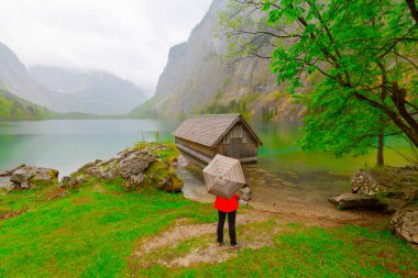Yaz aylarında mavi gökyüzü ve bulutlar ile güzel bir güneşli bir günde doğal Obersee Gölü'nde geleneksel eski ahşap tekne evi Pastoral görünümü, Millipark Berchtesgadener Land, Bavyera, Almanya