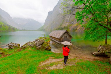 Yaz aylarında mavi gökyüzü ve bulutlar ile güzel bir güneşli bir günde doğal Obersee Gölü'nde geleneksel eski ahşap tekne evi Pastoral görünümü, Millipark Berchtesgadener Land, Bavyera, Almanya